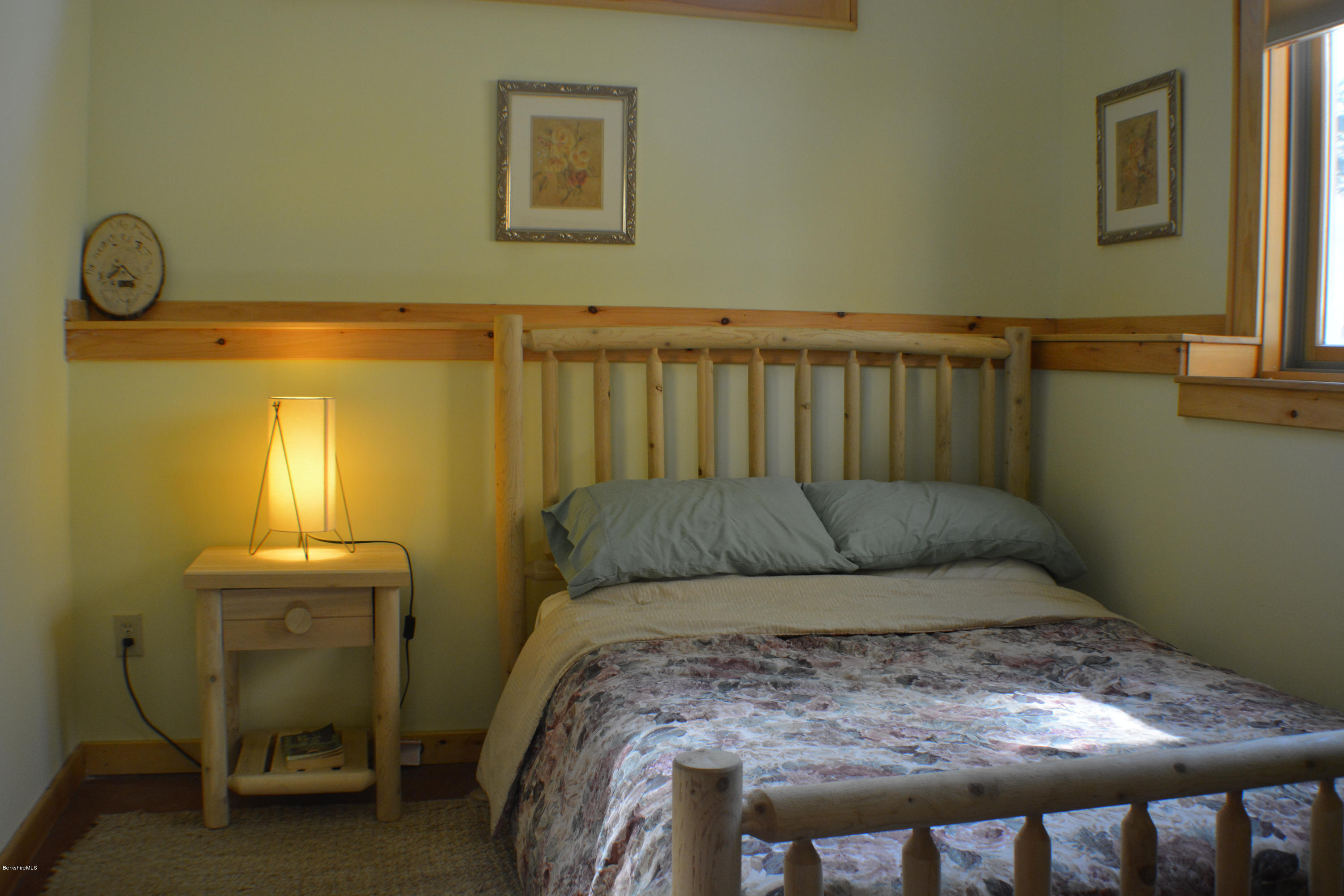 317 Pine Road Otis, MA 01029 - Photo 10 of 27 a bed sitting in a bedroom next to a lamp