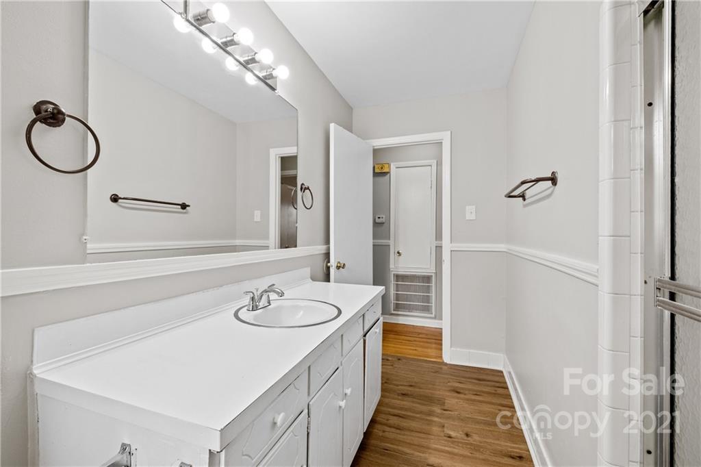 6833 Idlewild Road Charlotte, NC 28212 - Photo 13 of 24 a spacious bathroom with a granite countertop sink and a mirror
