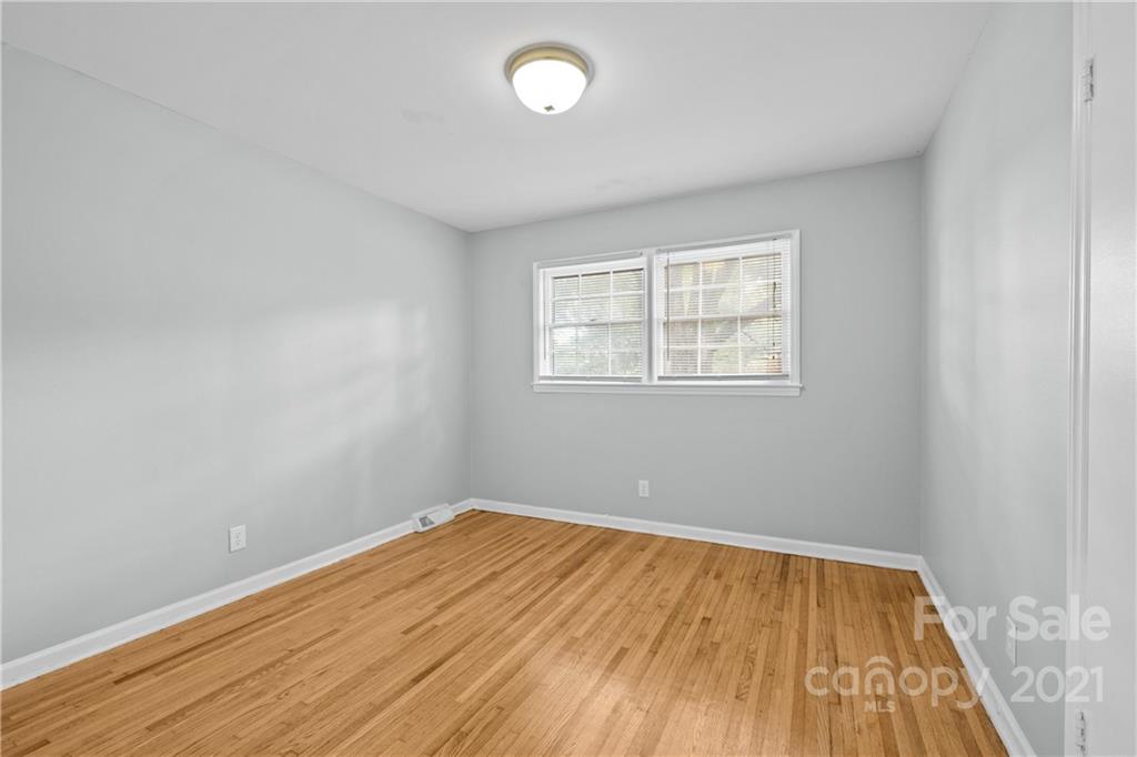 6833 Idlewild Road Charlotte, NC 28212 - Photo 14 of 24 an empty room with wooden floor and windows
