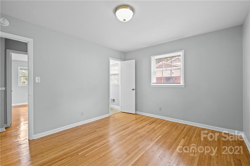 6833 Idlewild Road Charlotte, NC 28212 - Photo 19 of 24 an empty room with wooden floor and windows