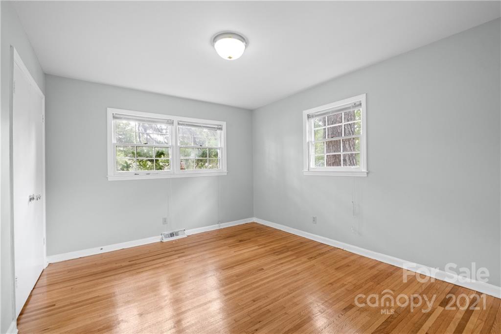 6833 Idlewild Road Charlotte, NC 28212 - Photo 21 of 24 a view of empty room with wooden floor and fan
