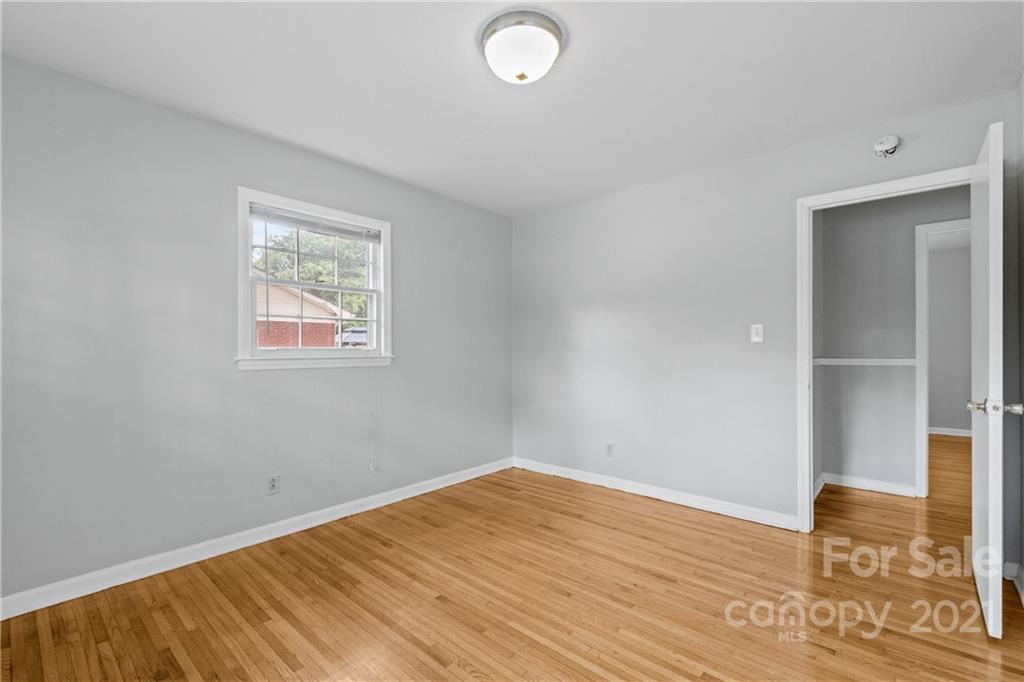 6833 Idlewild Road Charlotte, NC 28212 - Photo 23 of 24 an empty room with wooden floor and windows