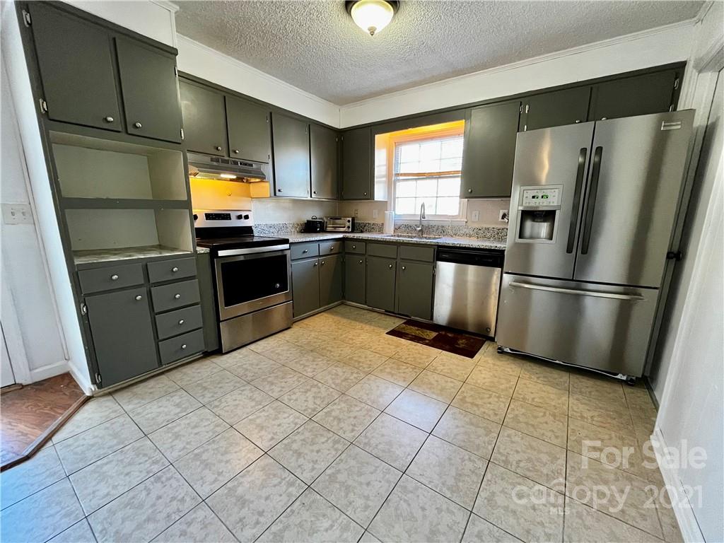 6833 Idlewild Road Charlotte, NC 28212 - Photo 5 of 24 a kitchen with stainless steel appliances a refrigerator and a sink