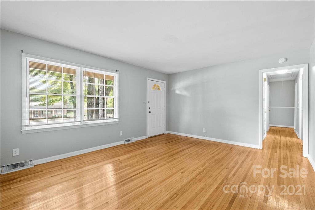 6833 Idlewild Road Charlotte, NC 28212 - Photo 9 of 24 a view of empty room with wooden floor and fan