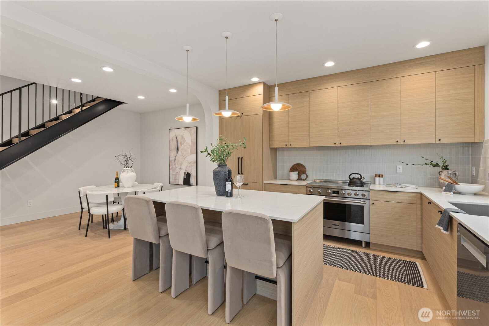 3409 Northwest 57th Street Seattle, WA 98107 - Photo 12 of 39 a kitchen with a dining table chairs sink and cabinets