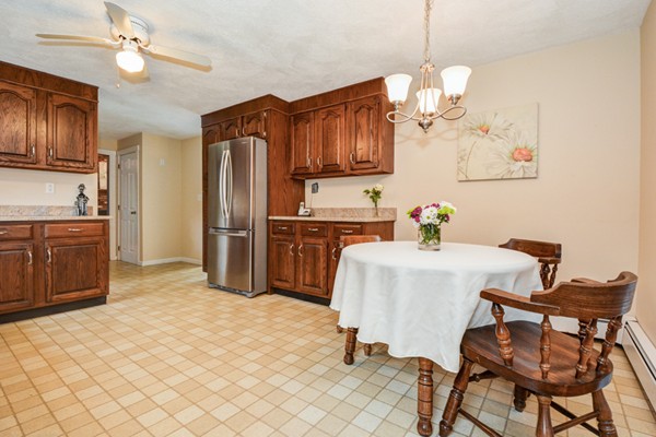 43 Robert Road Stow, MA 01775 - Photo 8 of 22 a kitchen with a table chairs refrigerator and cabinets