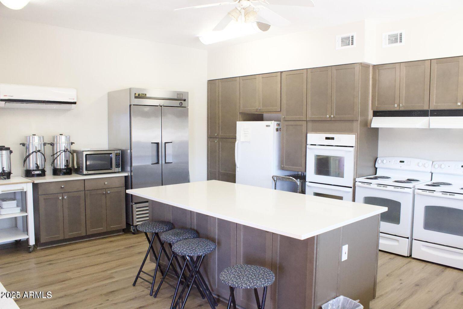 5735 East McDowell Road, Unit 63 Mesa, AZ 85215 - Photo 17 of 27 a kitchen with a table chairs refrigerator and cabinets