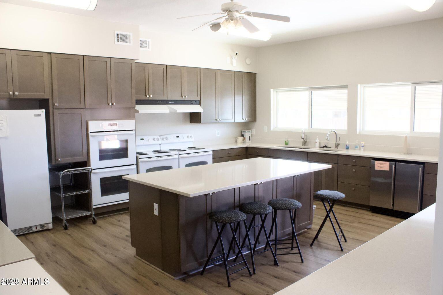 5735 East McDowell Road, Unit 63 Mesa, AZ 85215 - Photo 18 of 27 a kitchen with kitchen island granite countertop a sink appliances and cabinets