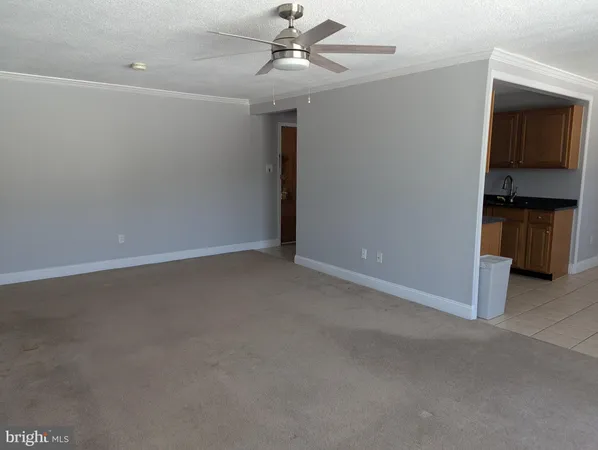 an empty room with a ceiling fan and closet area
