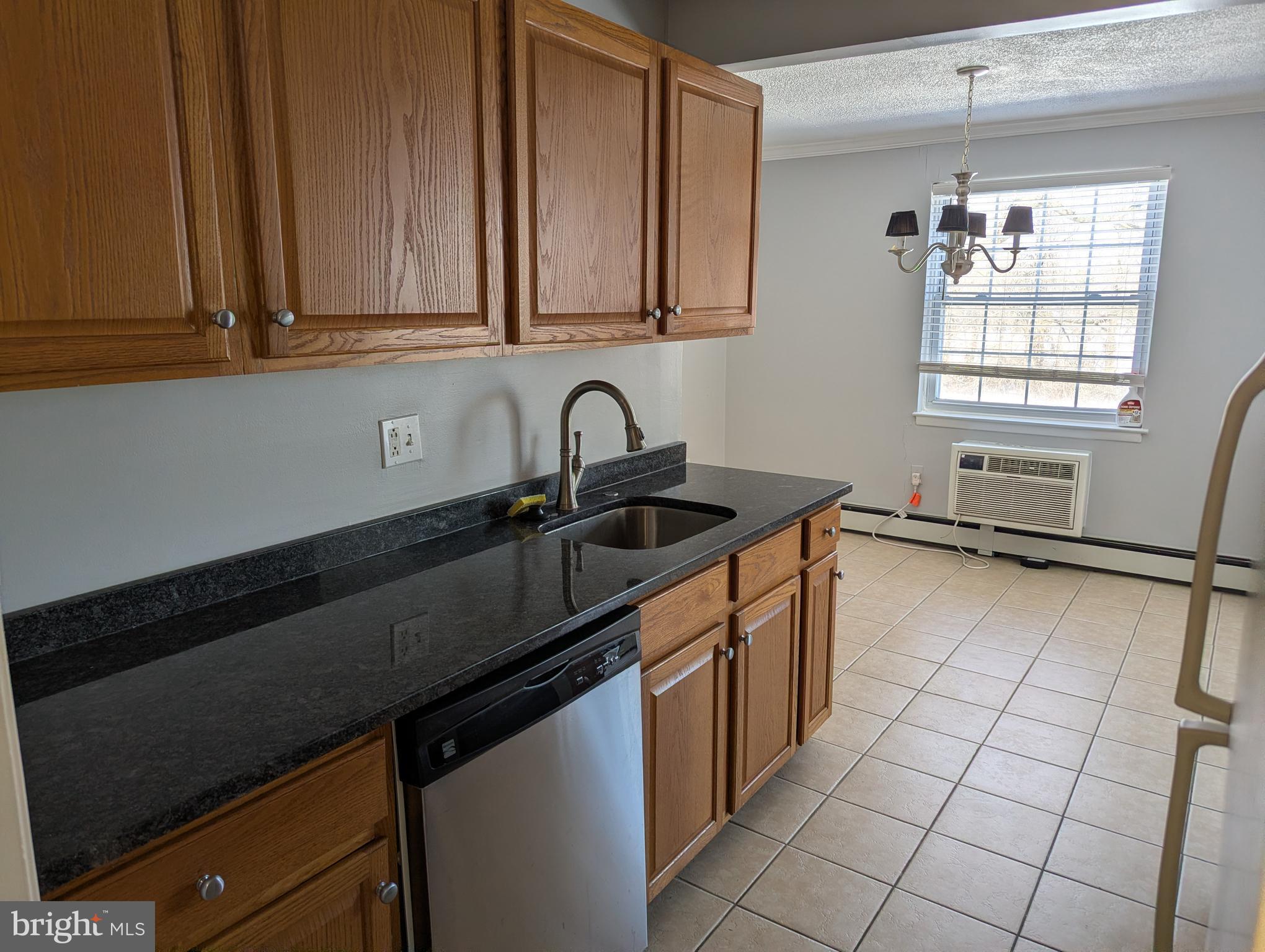 250 Ridge Pike, Unit CONDO 349 Lafayette Hill, PA 19444 - Photo 9 of 16 a kitchen with granite countertop a sink a stove and cabinets