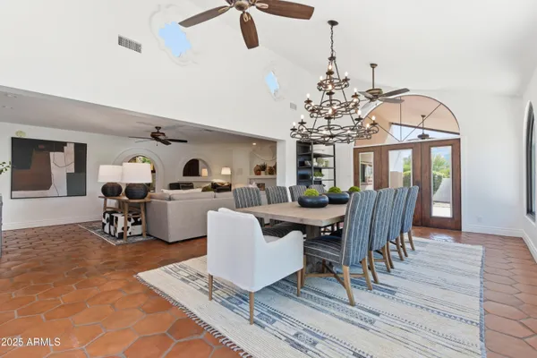 a living room with furniture a dining table and a chandelier