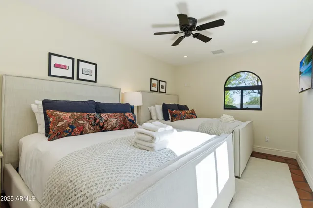 a bedroom with a large bed and a chandelier