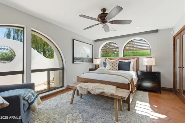 a bedroom with a bed a dresser next to a window