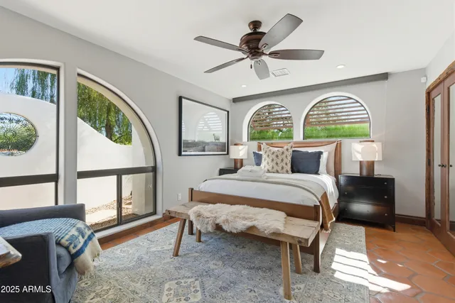 a bedroom with a bed a dresser next to a window