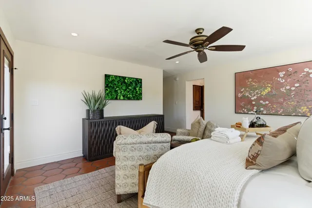 a bedroom with two beds and a potted plant