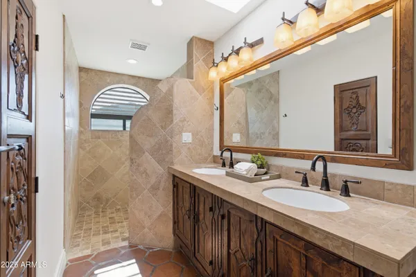 a bathroom with a granite countertop sink a mirror and a shower
