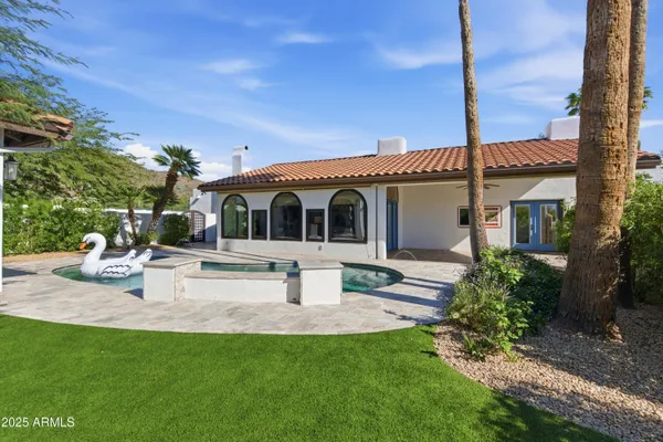 a front view of a house with garden and sitting area