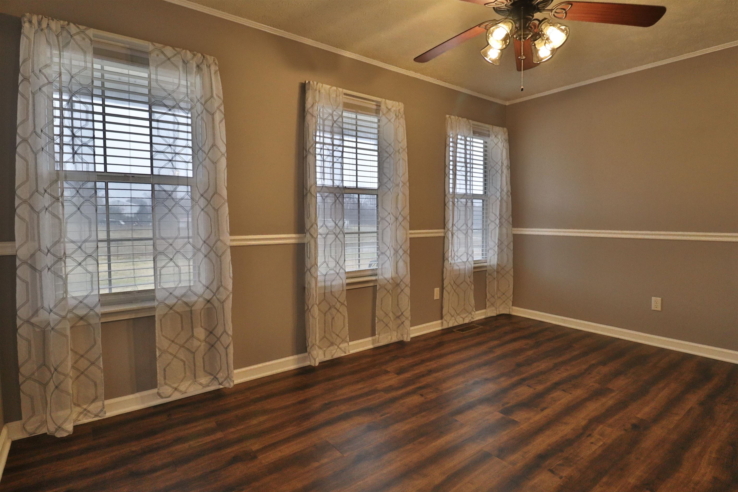 302 Ford Store Road Ripley, TN 38063 - Photo 5 of 40 an empty room with wooden floor and windows
