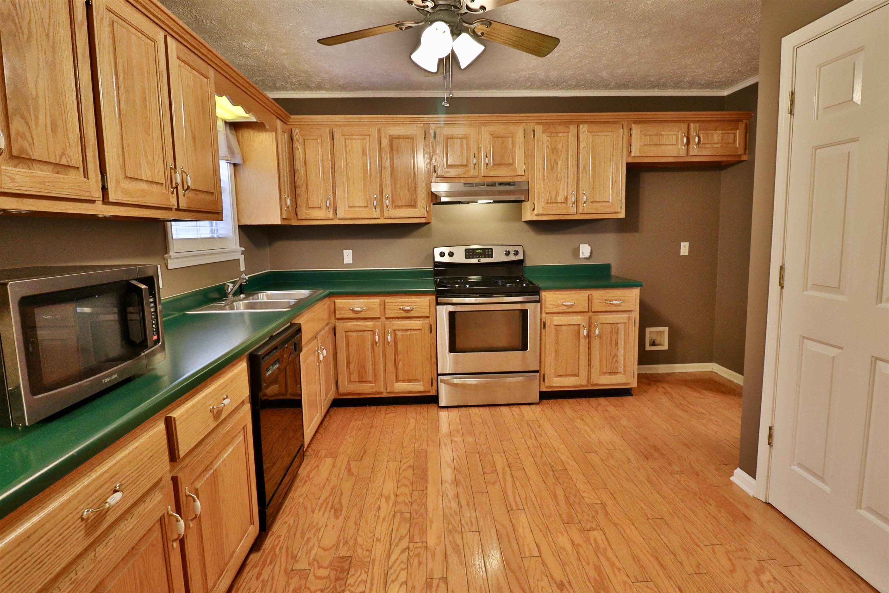 302 Ford Store Road Ripley, TN 38063 - Photo 10 of 40 a kitchen with stainless steel appliances granite countertop wooden cabinets a stove a sink and dishwasher