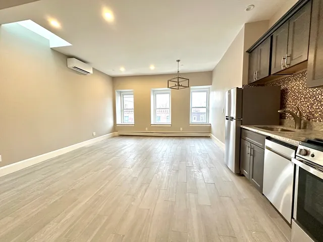 a view of a kitchen with wooden floor and electronic appliances