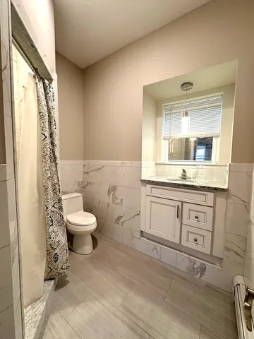 a bathroom with a toilet sink and mirror