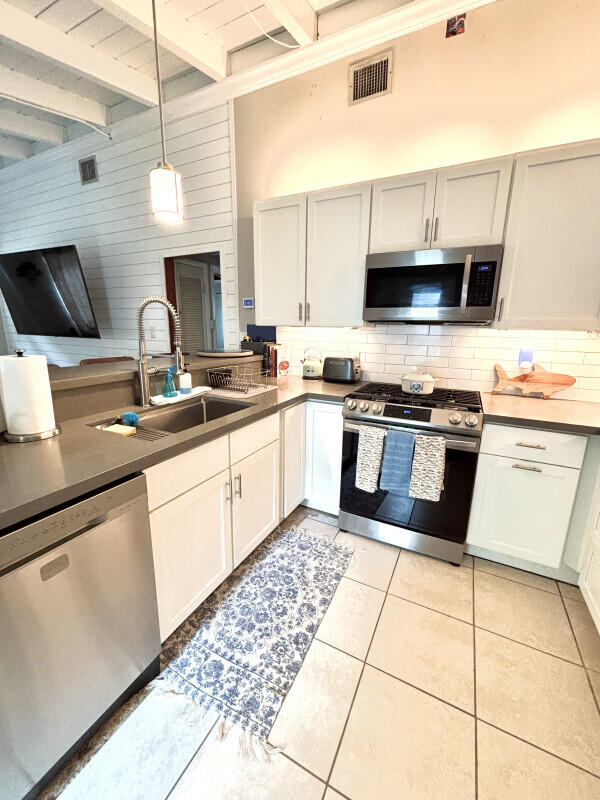 124 South Hammock Road Islamorada, FL 33036 - Photo 5 of 11 a kitchen with stainless steel appliances a sink a stove top oven a counter space and cabinets