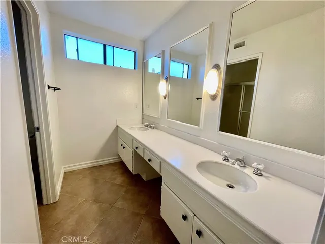 a bathroom with a double vanity sink and mirror