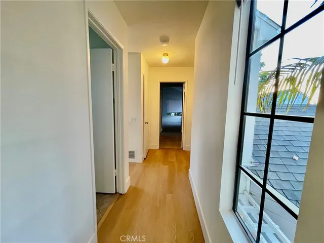 a view of a hallway with wooden floor and staircase