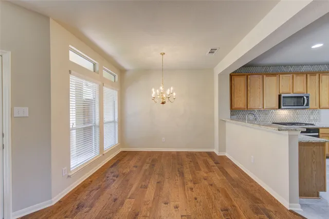 a view of a kitchen with wooden floor and a window
