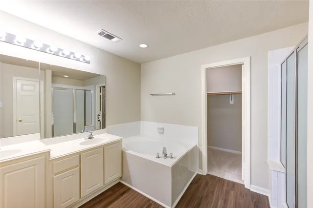 a bathroom with a tub a sink and a mirror