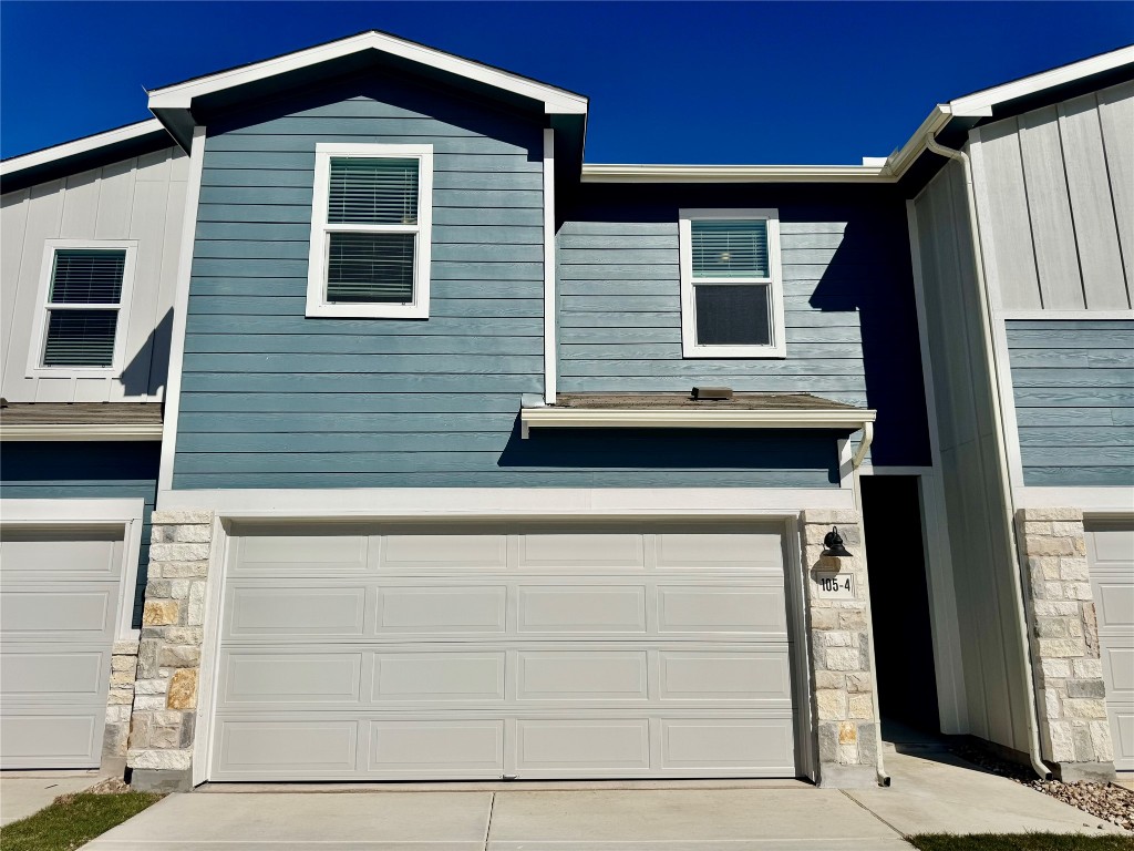 View of front of property featuring stone siding and driveway