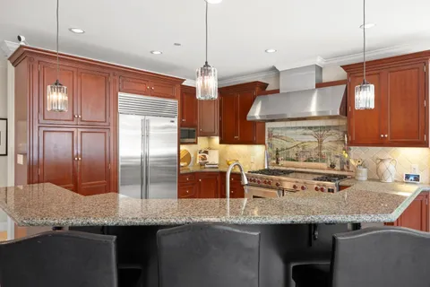 a kitchen with stainless steel appliances a sink stove and cabinets