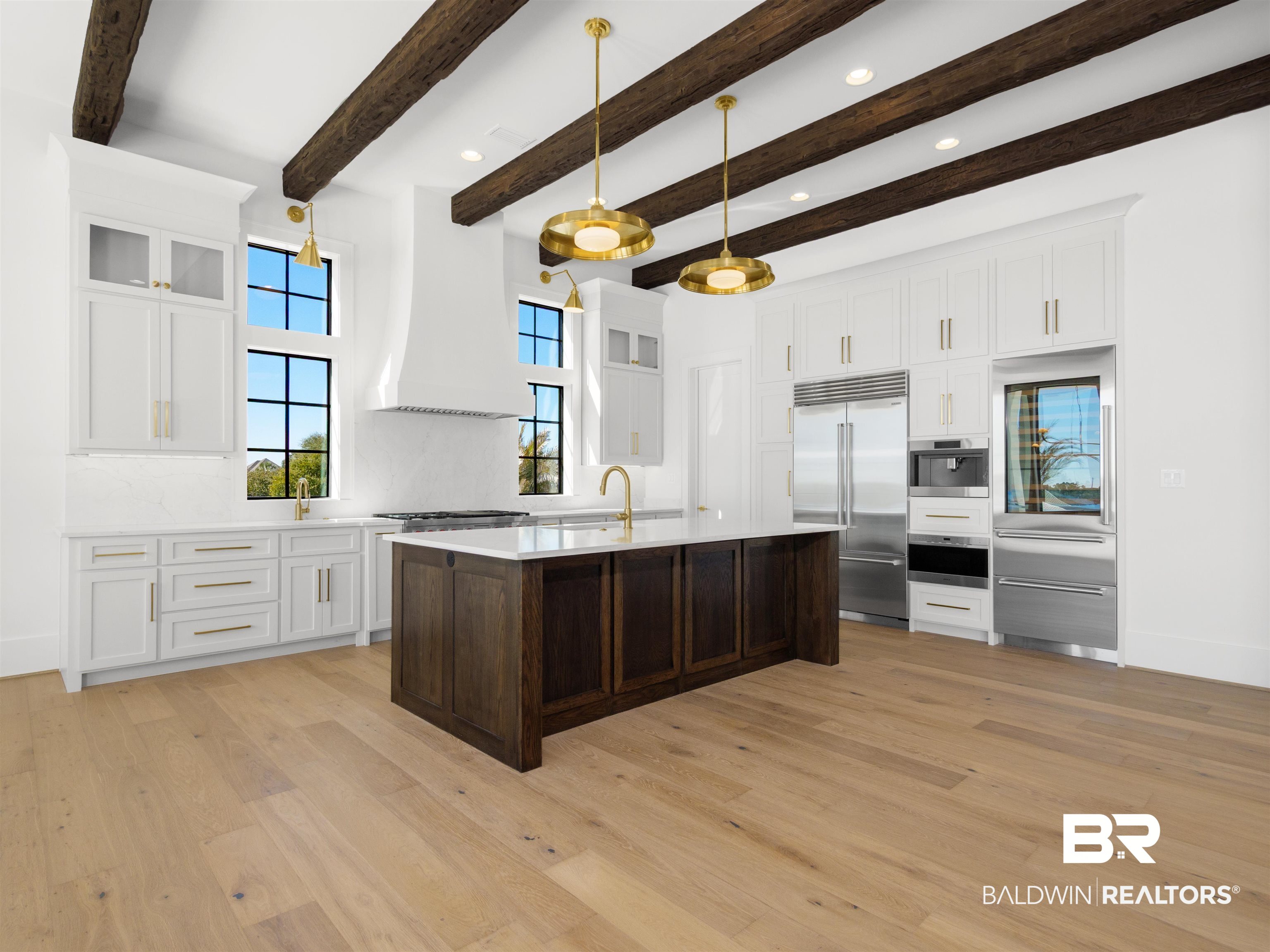 31292 River Road Orange Beach, AL 36561 - Photo 8 of 48 Kitchen featuring custom exhaust hood, stainless steel appliances, light countertops, light wood-type flooring, and white cabinetry