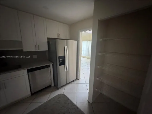 a kitchen with a refrigerator and cabinets