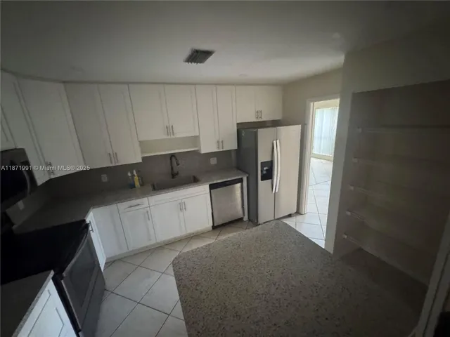a kitchen with a refrigerator and cabinets