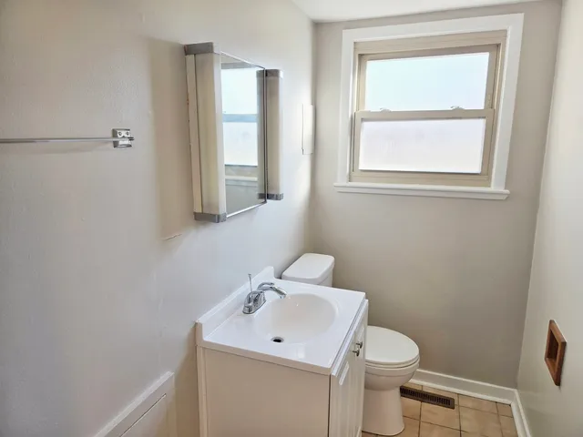 a bathroom with a toilet sink vanity and mirror