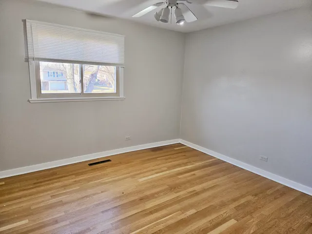 a view of a room with wooden floor and a window