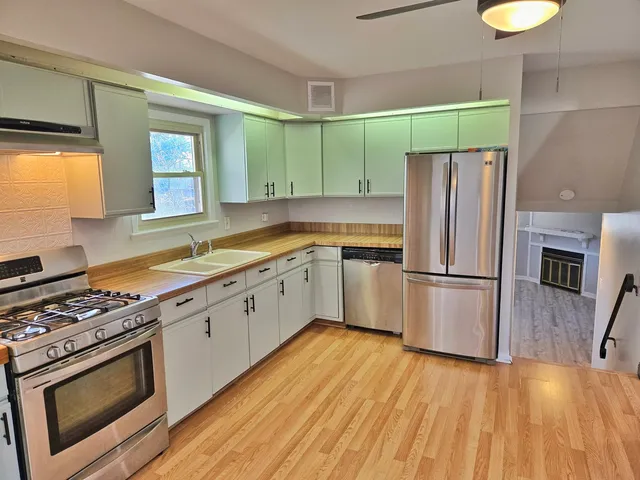 a kitchen with stainless steel appliances a stove a sink and a refrigerator