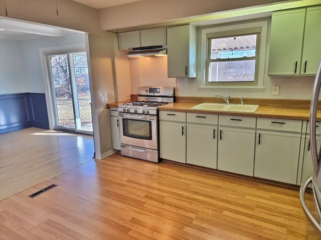 a kitchen with stainless steel appliances granite countertop a sink and wooden cabinets