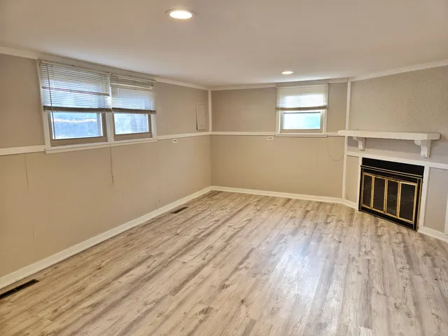 a view of empty room with wooden floor and window