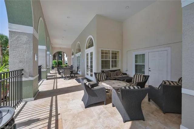 a living room with furniture large windows and wooden floor