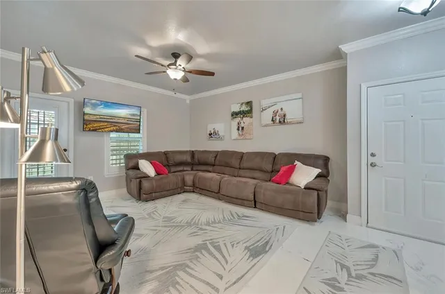 a living room with furniture and a ceiling fan
