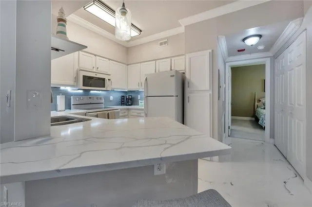 a view of a kitchen with a sink and a refrigerator
