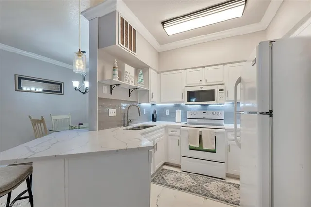 a kitchen with stainless steel appliances a sink stove refrigerator and cabinets