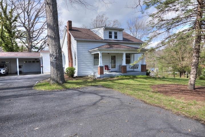 a view of a house with a yard and large tree