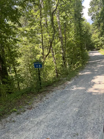 a sign board with a house in the background
