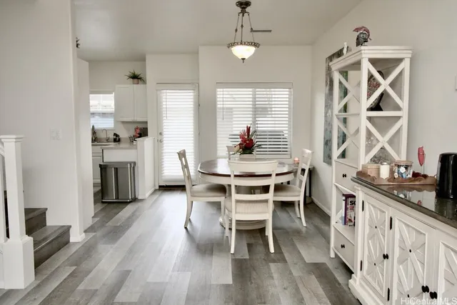 a dining room with wooden floor a chandelier a wooden table and chairs
