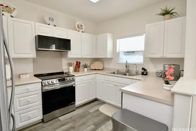 a kitchen with stainless steel appliances white cabinets and white appliances