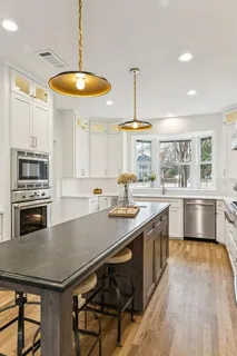 a kitchen with stainless steel appliances granite countertop a sink stove and refrigerator