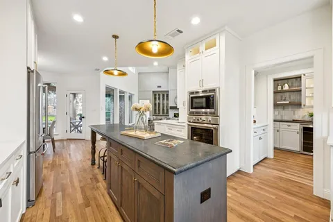 a kitchen with stainless steel appliances granite countertop a sink and a white cabinets